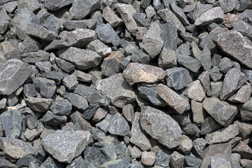 Gray textured surface of a heap of construction pebbles and gravel