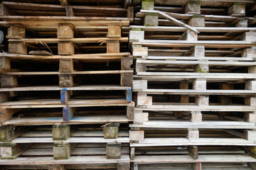 Stacks of old used discarded wooden shipping pallets 