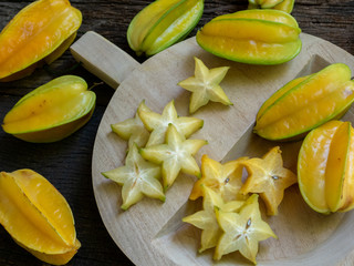 Fresh organic cut star fruit on wooden chopping board