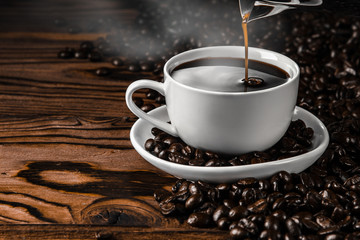 Still-life with a cup of black coffee and roasted coffee beans close up