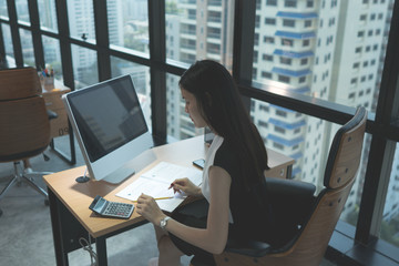 working woman sitting and work with document on desk in office building