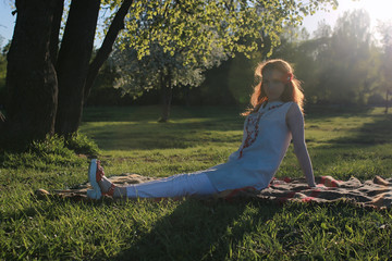 A girl on a walk in an autumn park. Young red-haired girl in the spring on nature.