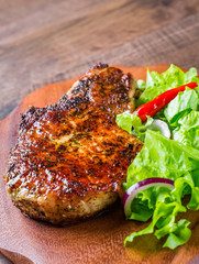 Pork Loin chops marinated meat Steak with vegetables slad on wooden table background