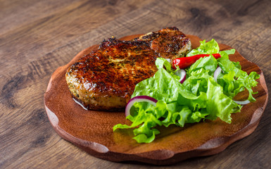 Pork Loin chops marinated meat Steak with vegetables slad on wooden table background