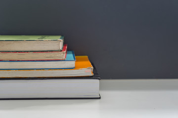 Close up books stacked on the table at the university library in selective focus.