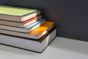 Close up books stacked on the table at the university library in selective focus.