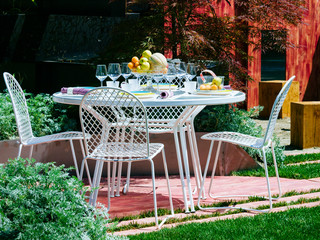 Tranquillo angolo del giardino con il tavolo apparecchiato per il pranzo