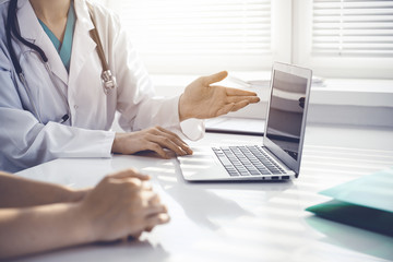 Doctor and patient are discussing something in clinic, just hands at the desk. Medicine and best service concept