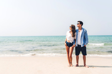 Romantic lovers young couple relaxing together on the tropical beach.Man hugging with woman and enjoy life.Summer vacations