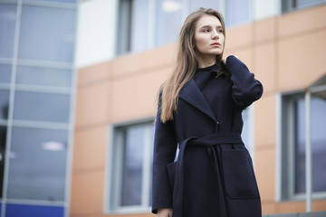 Beautiful girl in a coat in business downtown