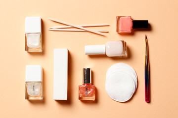 A set of tools for manicure and nail polish on a pink background