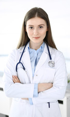 Doctor woman standing straight with arms crossed, portrait. Perfect medical service in clinic. Medicine and healthcare concepts