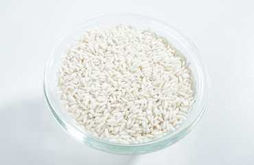 Glass bowl filled with a bowl of white glutinous rice on a white background
