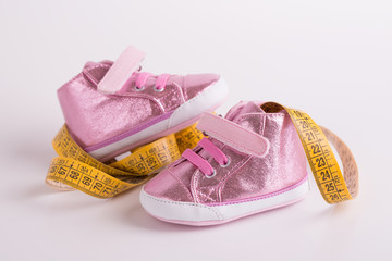 Measurement of children's shoes. Children's shoes. Growth foot baby. Dimensional yellow ribbon and baby shoes.