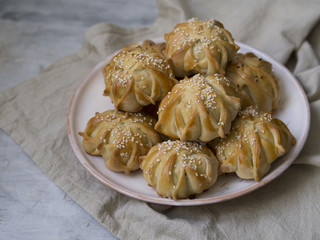 Interestingly shaped fresh meat mini pie. Delicious samosa pies with meat on plate on gray background. Menu, restaurant, recipe concept. Selected focus, close up, copy space.