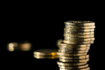 Golden coins close up. Stack of gold coins on a black background.
