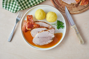 Deutscher Schweinebraten mit Kruste und Knödel auf weißem Hintergrund top view restaurant