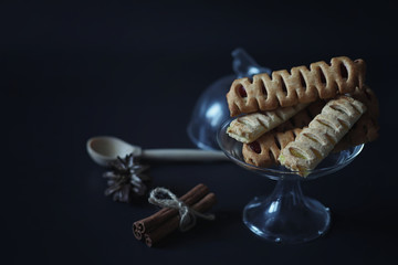 Set for breakfast. Sweets and pastries with nuts for tea on a black background. A coffee cup and patties.