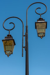 Fototapeta na wymiar Old street lamps on a blue summer sky