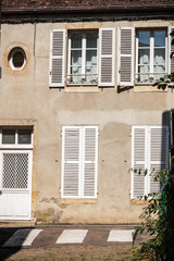 Old house facade with shutter and white door