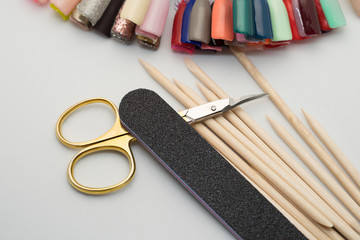 Manicure tools on a white background. Scissors, nail file, sticks, etc.