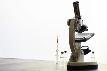 Research laboratory. Test tubes and microscope on the table on a white background.