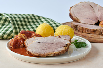 Deutscher Schweinebraten mit Kruste und Knödel auf weißem Hintergrund 