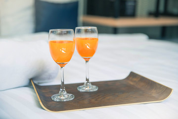 Bed breakfast with orange juice on white sheets. Healthy breakfast with orange juice in wooden tray. bed breakfast.