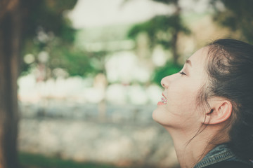 Young happy woman face smile with gum in nature take a deep breath feeling fresh. gums receding...
