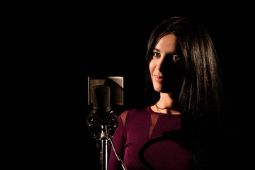 Portrait of woman recording a song in a professional studio