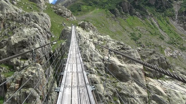 Walk through Trift Bridge, around lake, glacier and mountains, national park Switzerland, Europe. Summer landscape, sunshine weather and sunny day