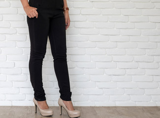 woman wearing long trousers. and high-heel shoes standing .