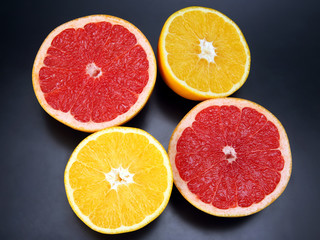 Citrus fruit. Cut orange and grapefruit on dark background