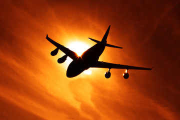 The plane flying in the sky against the setting sun. air transportation, travel, air transport.