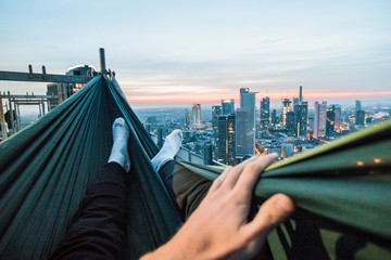Urban Explorer sleeping in a hammock over the roofs of Frankfurt am Main