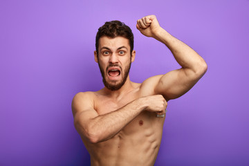 angry man is shouting during depilation, close up photo.studio shot. masochism concept
