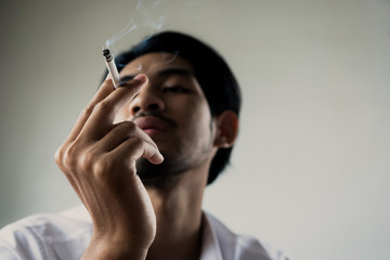 World No Tobacco Day in May, stop smoking and against  concept, young man holding cigarette in dark tone
