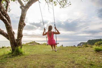 woman swinging on a swing on a tropical island