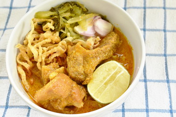 Thai northern style curry noodles in coconut milk soup with pork on bowl