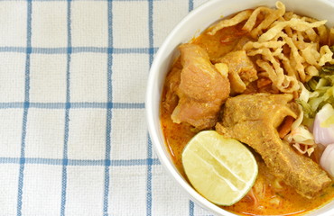 Thai northern style curry noodles in coconut milk soup with pork on bowl