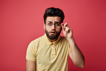 funny man with bad eyesight trying to see written on poster, board.expresses surprise , close up...