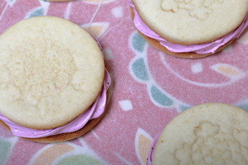 Cooked marshmallow sandwiches. They lie on food paper.