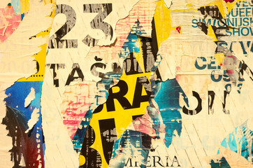 Old grunge ripped torn vintage collage colorful street posters creased crumpled paper surface backdrop