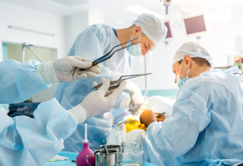 Brain surgery. Group of surgeons in operating room with surgery equipment.