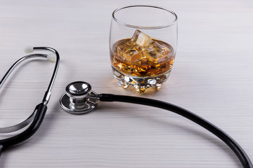 Medical concept - Stethoscope and glass with cognac. Alcoholism