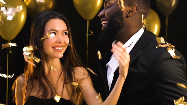 Beautiful Asian woman seductively dancing with Afro-American man, temptation