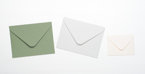 Green and white envelopes on a white background. Concept of letters, messages, correspondence, copy space, top view, flat lay.