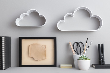 Mock up blank frame on stylish desk with cloud shelfs on the wall.