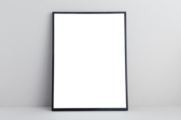 Black empty poster frame on gray neutral background,