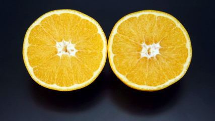Citrus fruit. Cut orange on dark background